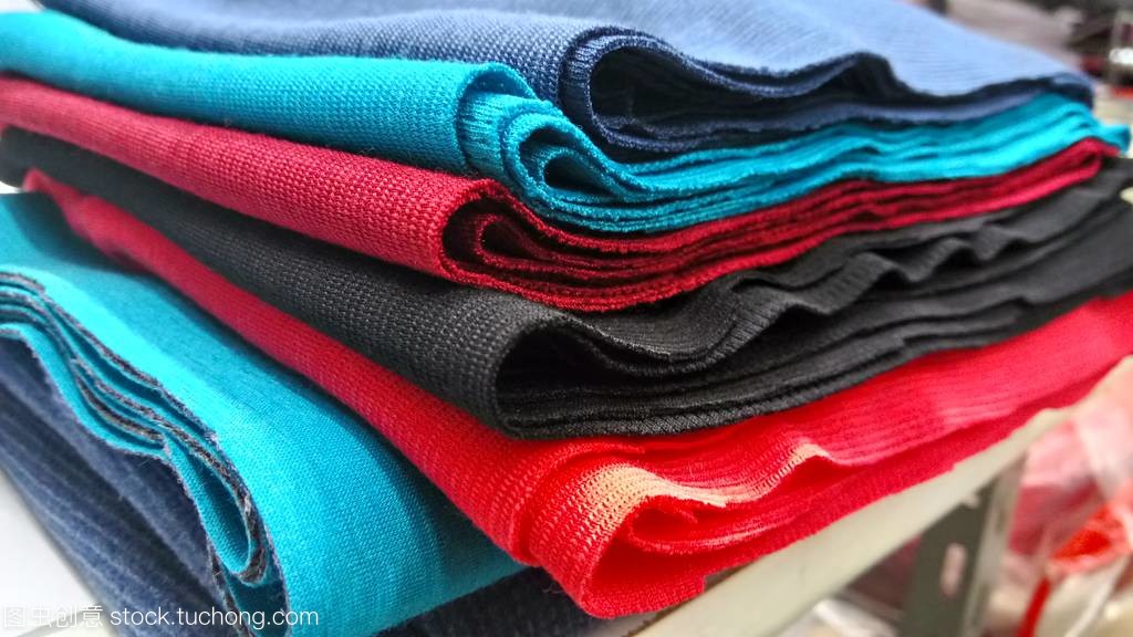 新工业橙色、 黑色、 红色和蓝色卷背景。概念: 材料、 织物、 制造、 服装厂、 新样品的织物